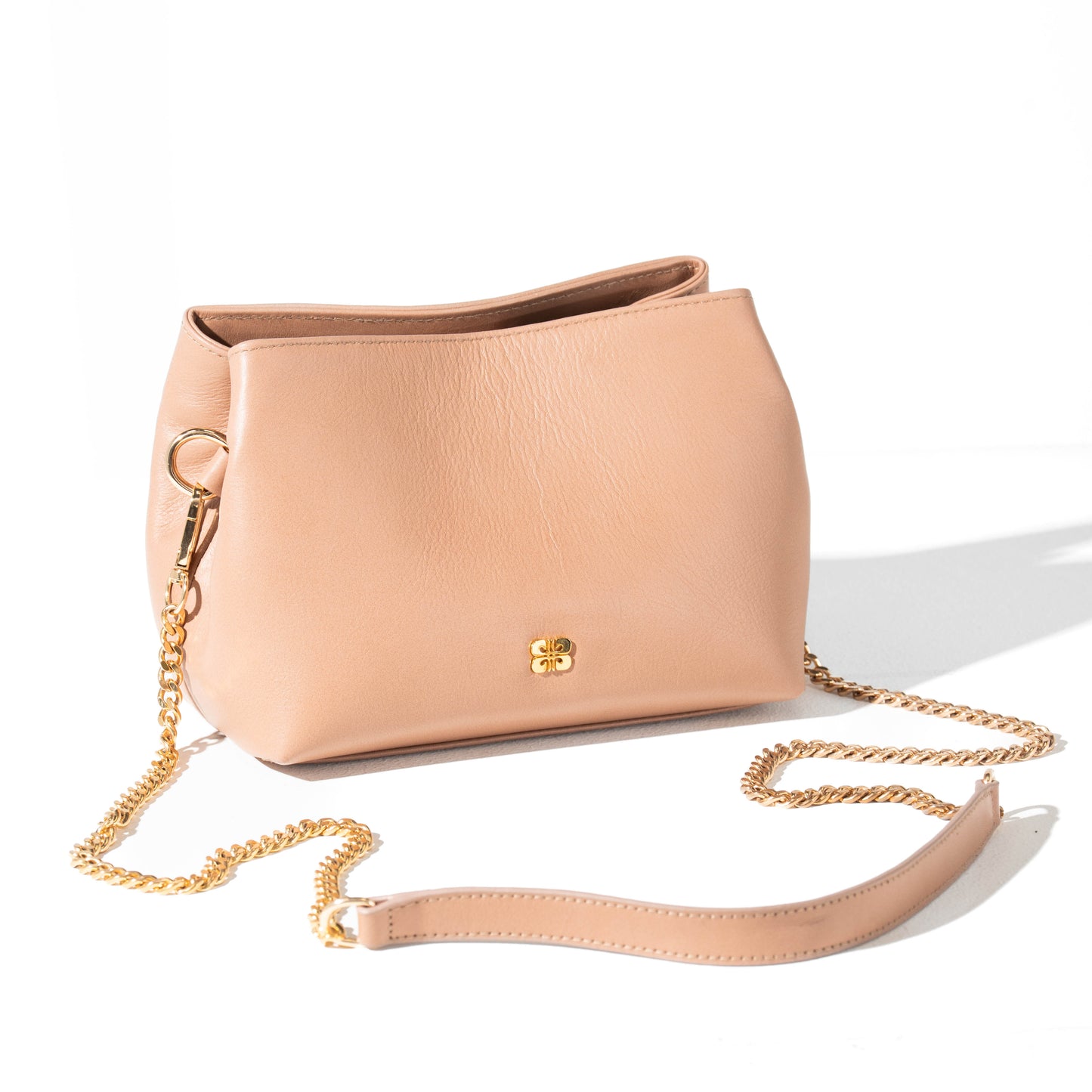 Beige handbag with a gold logo on a white background
